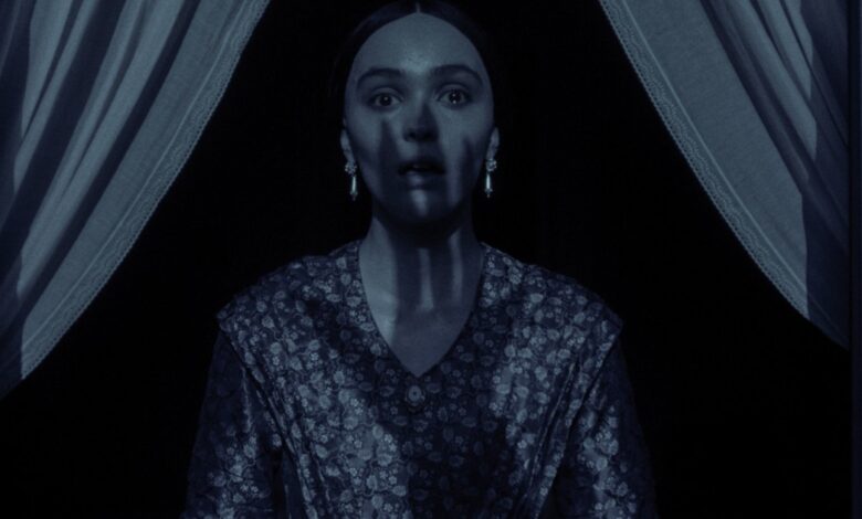 a clawed hands shadow covers lily rose depp in nosferatu.jpg